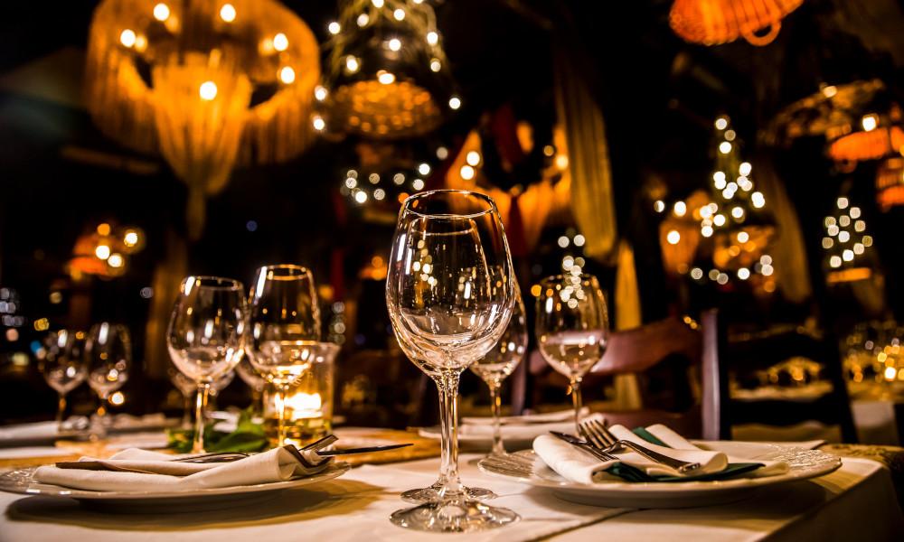 餐厅的餐桌，配有酒杯、盘子和银器.